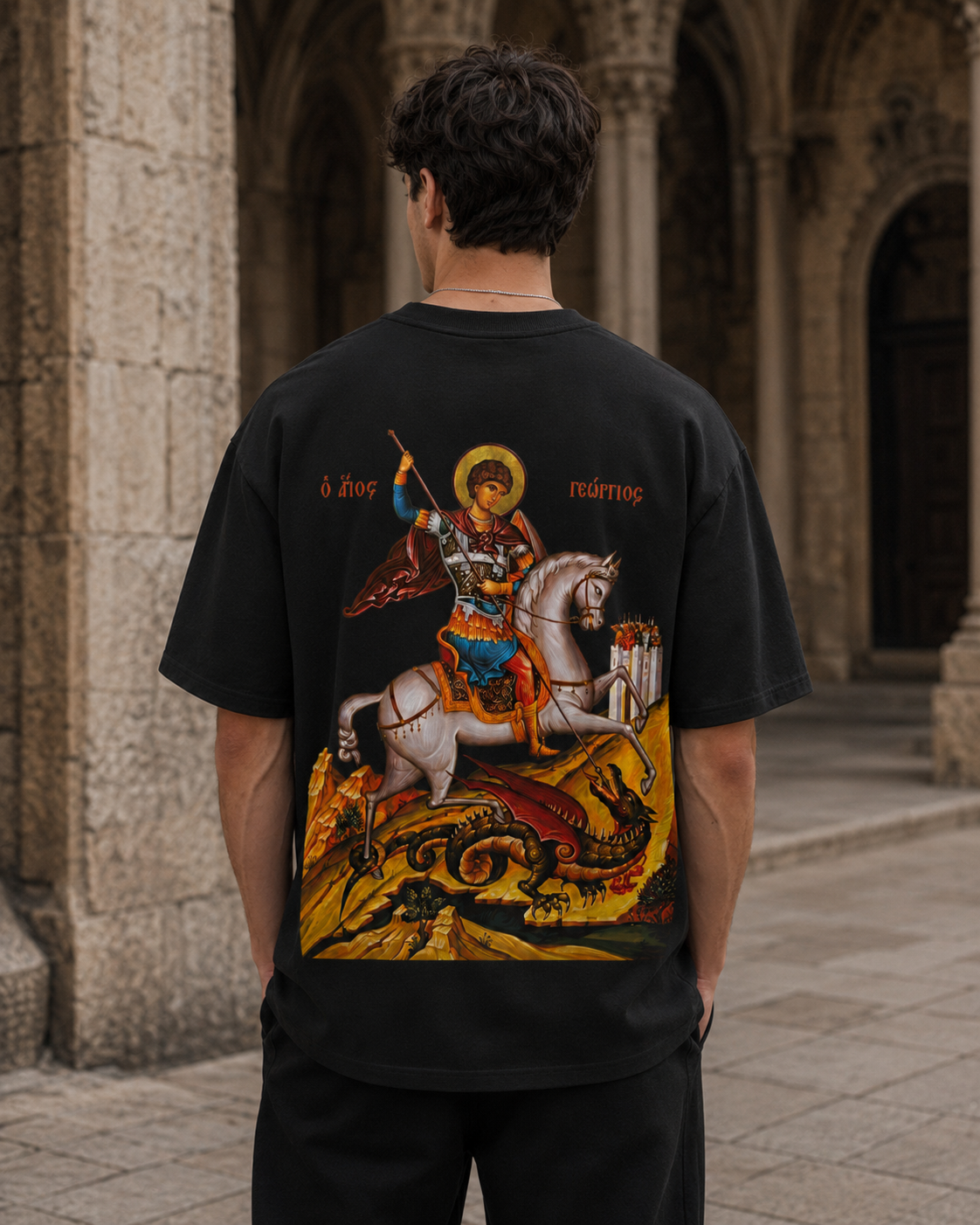 Black CRVX Saint George hoodie worn in a stone street